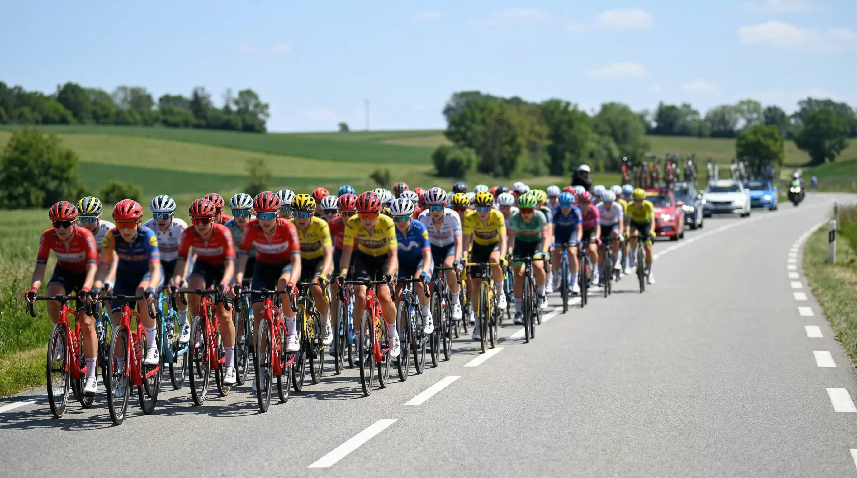 Pelotón femenino de ciclismo en carretera rodando en grupo compacto durante una etapa