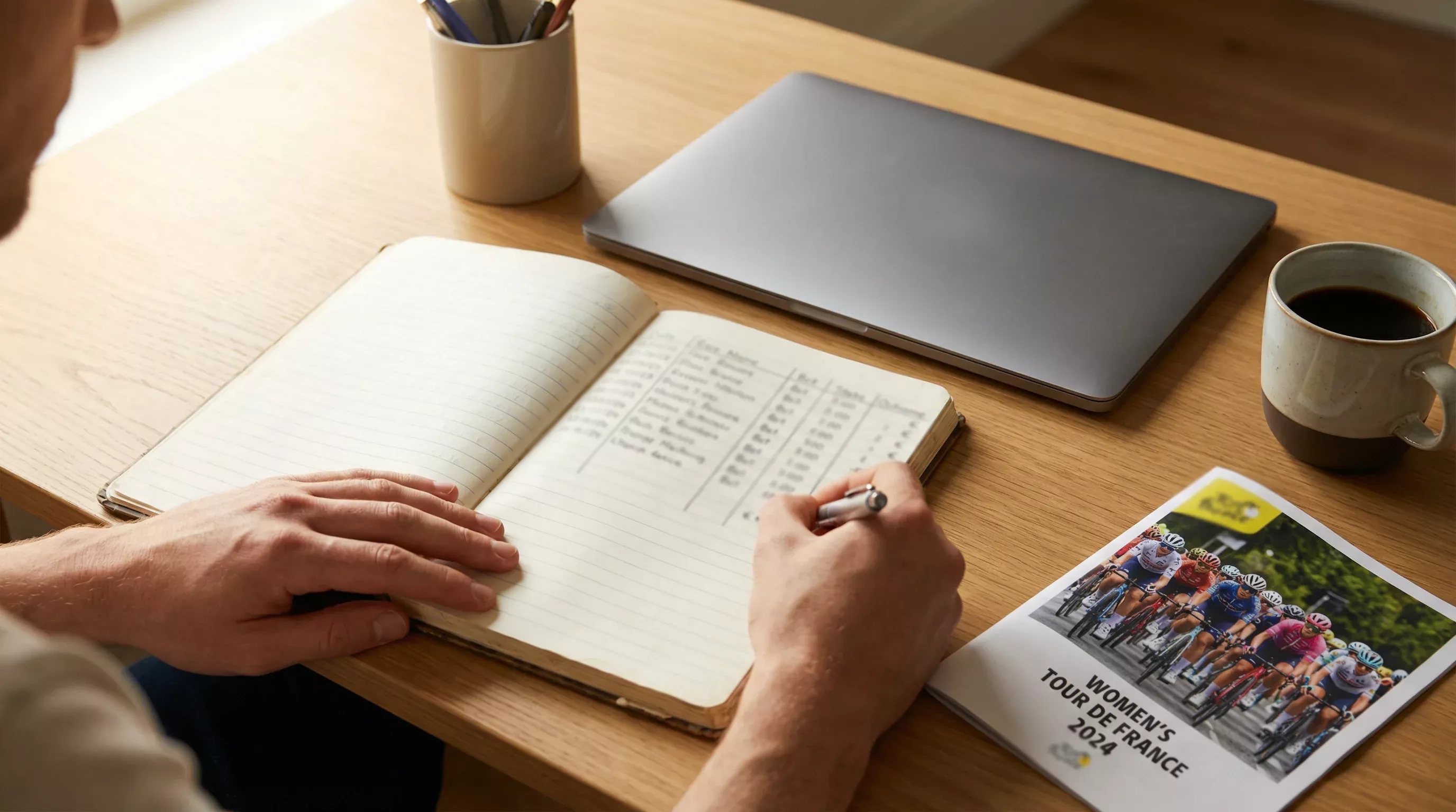 Persona planificando su presupuesto de apuestas de ciclismo femenino con libreta y anotaciones